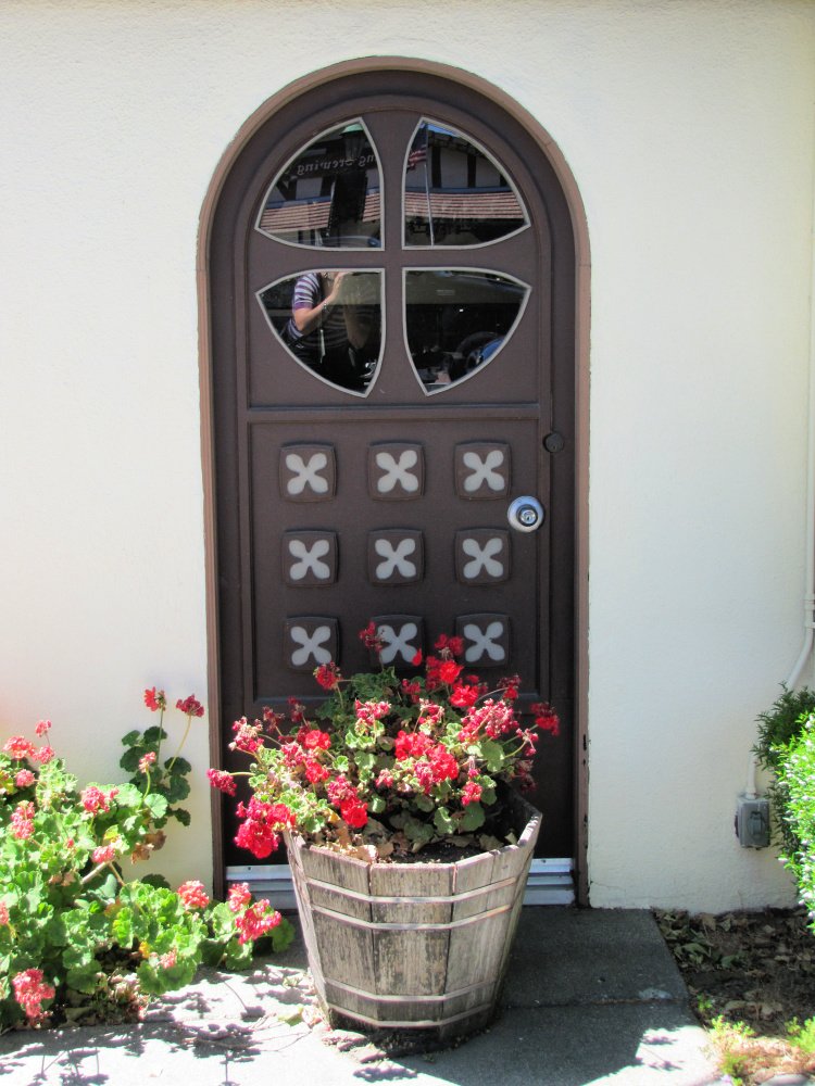 Brown door and red flowers in Solvang, California